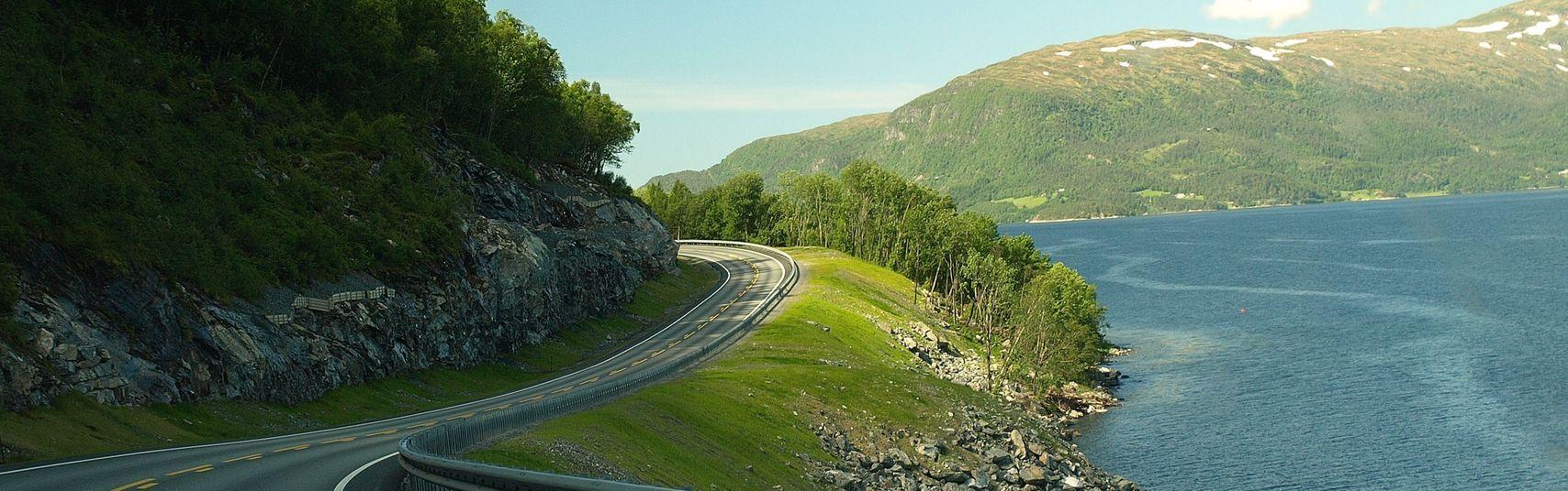 En väg bland berg och skog